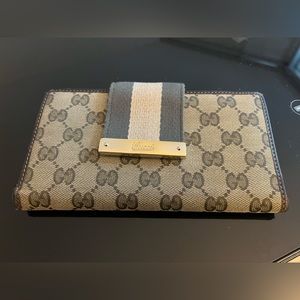 Authentic Gucci canvas wallet with large belt like snap closure.